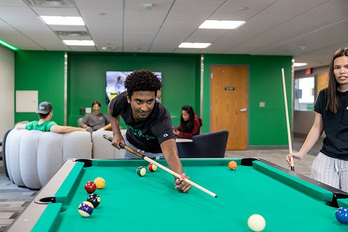 student playing pool at Brannon Hall