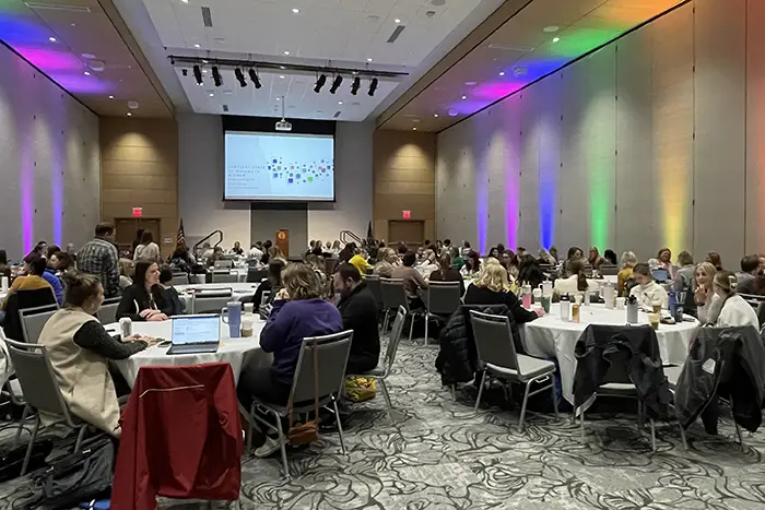 people sitting at round tables at an LGBTQ event