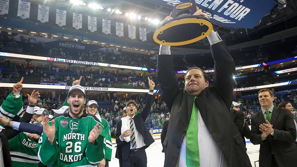 Coach Berry raising the 2016 NCAA National Hockey Trophy