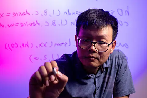 Harry Zou writing code on a wall