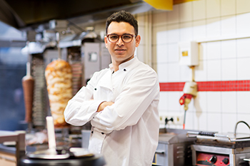 Male chef crossing his arms in the kitchen