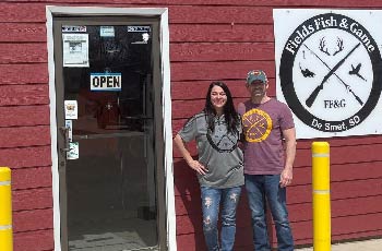 David and Amanda Fields standing in front of their store, Fields Fish and Game in DeSmet, SD