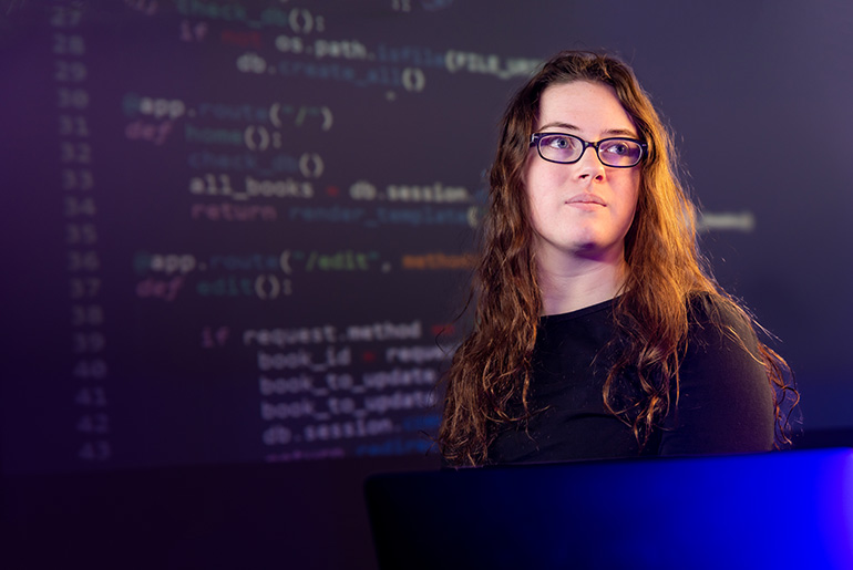 Julia Dewhurst at a laptop in front of her web code