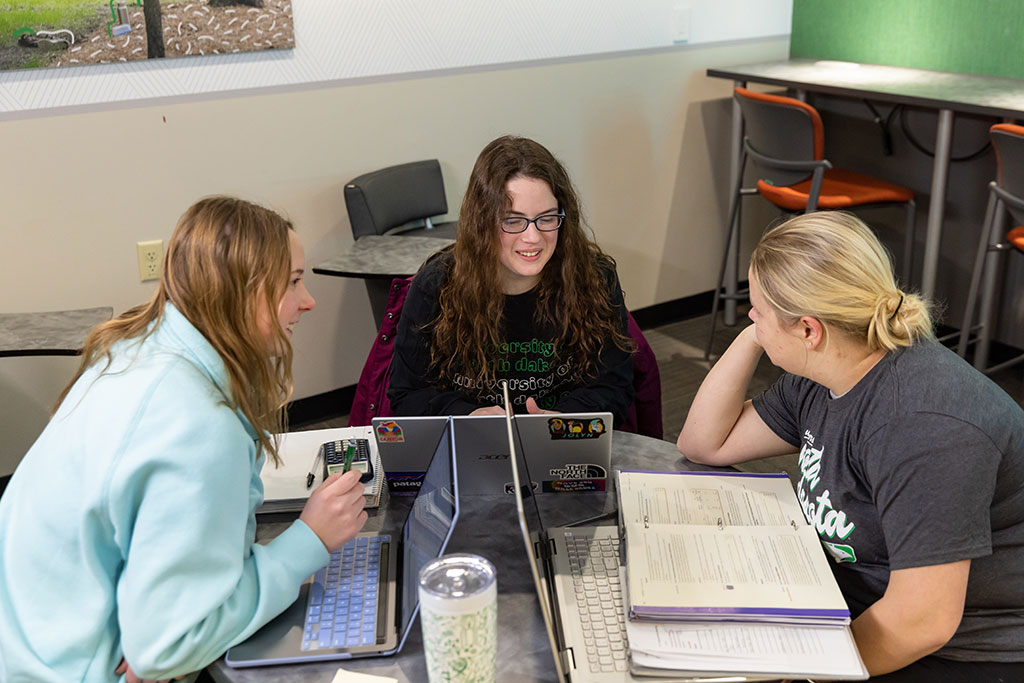 Julia at study table with two friends