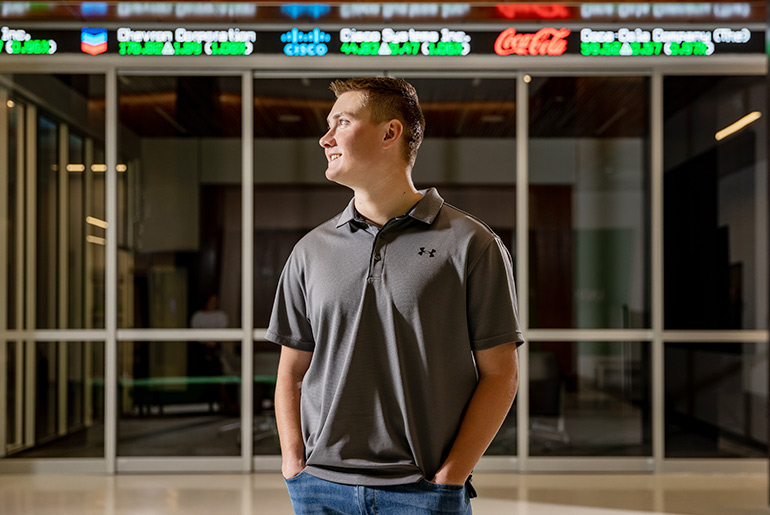 Kaden Kueneman looking left in front of stock numbers