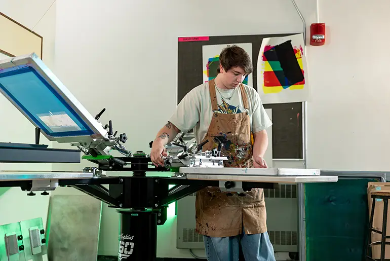 Tucker works on a screenprinting machine