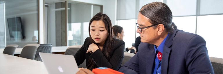 MPH degree student with faculty going over public health data