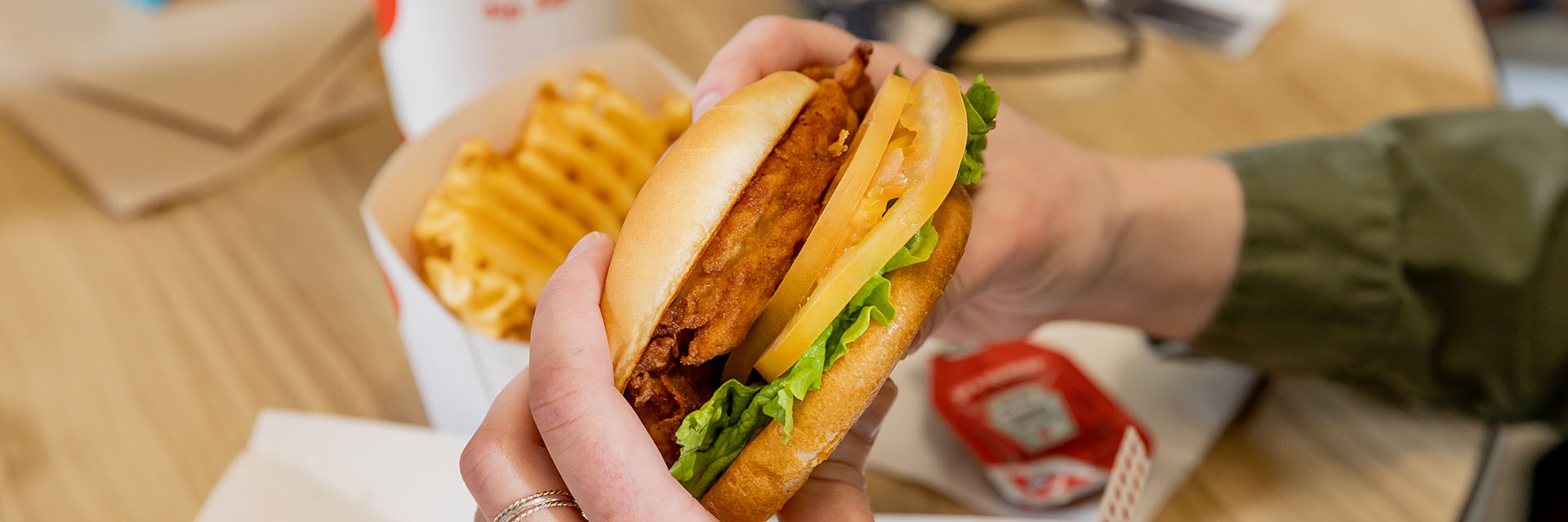 a chicken sandwich held up by a student